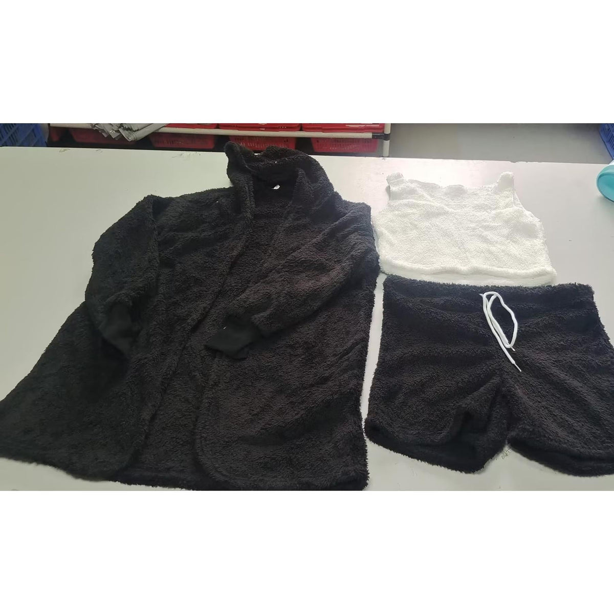 Supplier photograph of the included black cardigan, white cropped tank and black shorts with white drawstring