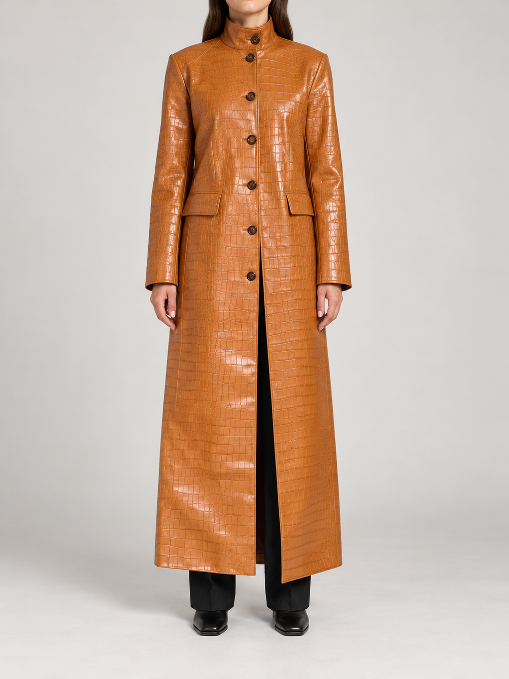 caramel-brown ankle-length crocodile embossed glossy single-breasted coat with stand collar and rectangular flap pockets, front view on a model