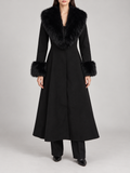 black calf-length flared coat with fitted waist, voluminous faux-fur shawl collar and furry cuffs, front view on a model