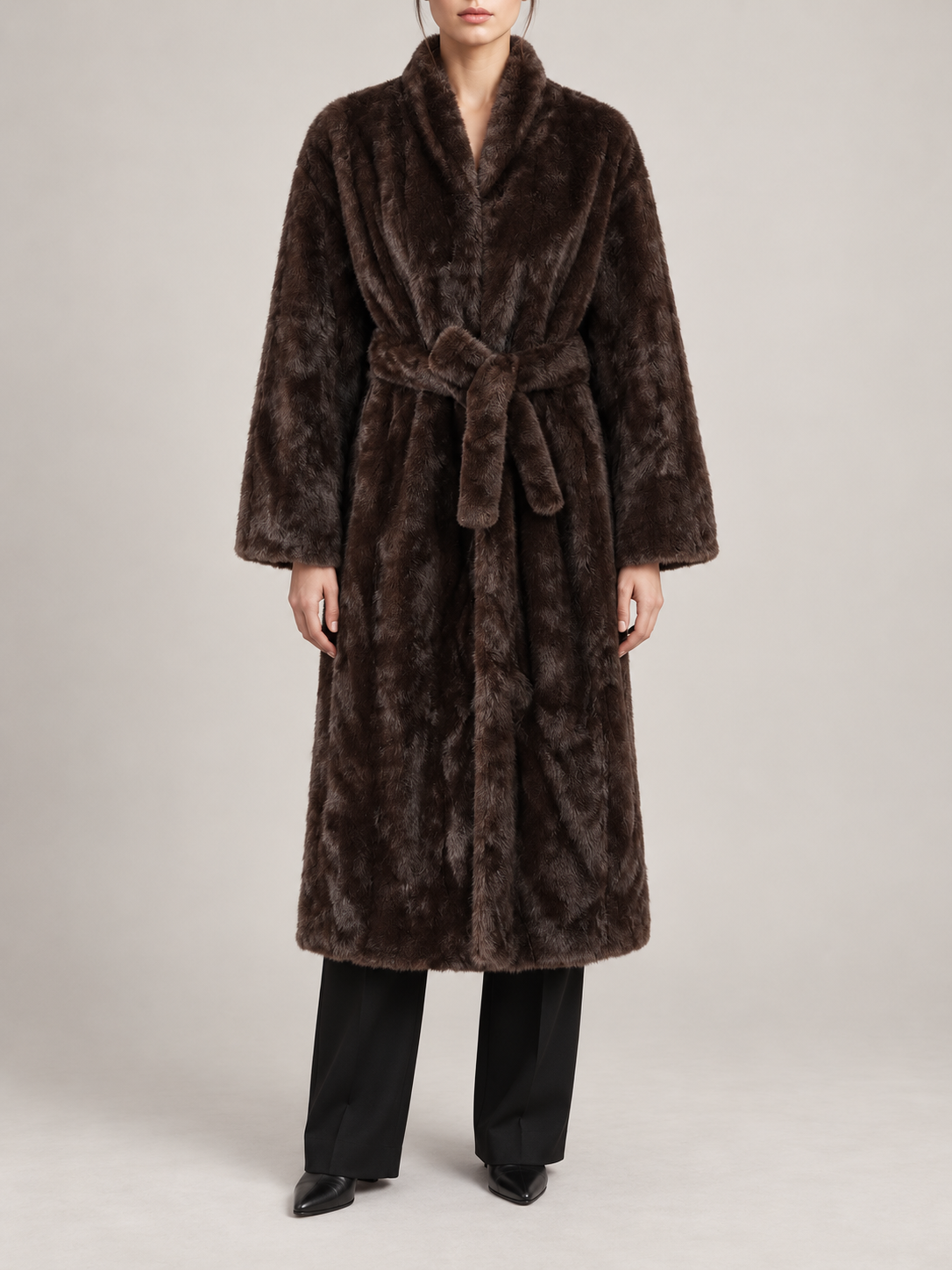 dark brown long faux-fur wrap coat with matching waist tie, slim rounded shawl collar, broad straight sleeves, front view on a model
