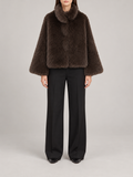 dark brown short plush faux-fur jacket with rounded high collar and wide straight sleeves, front view on a model