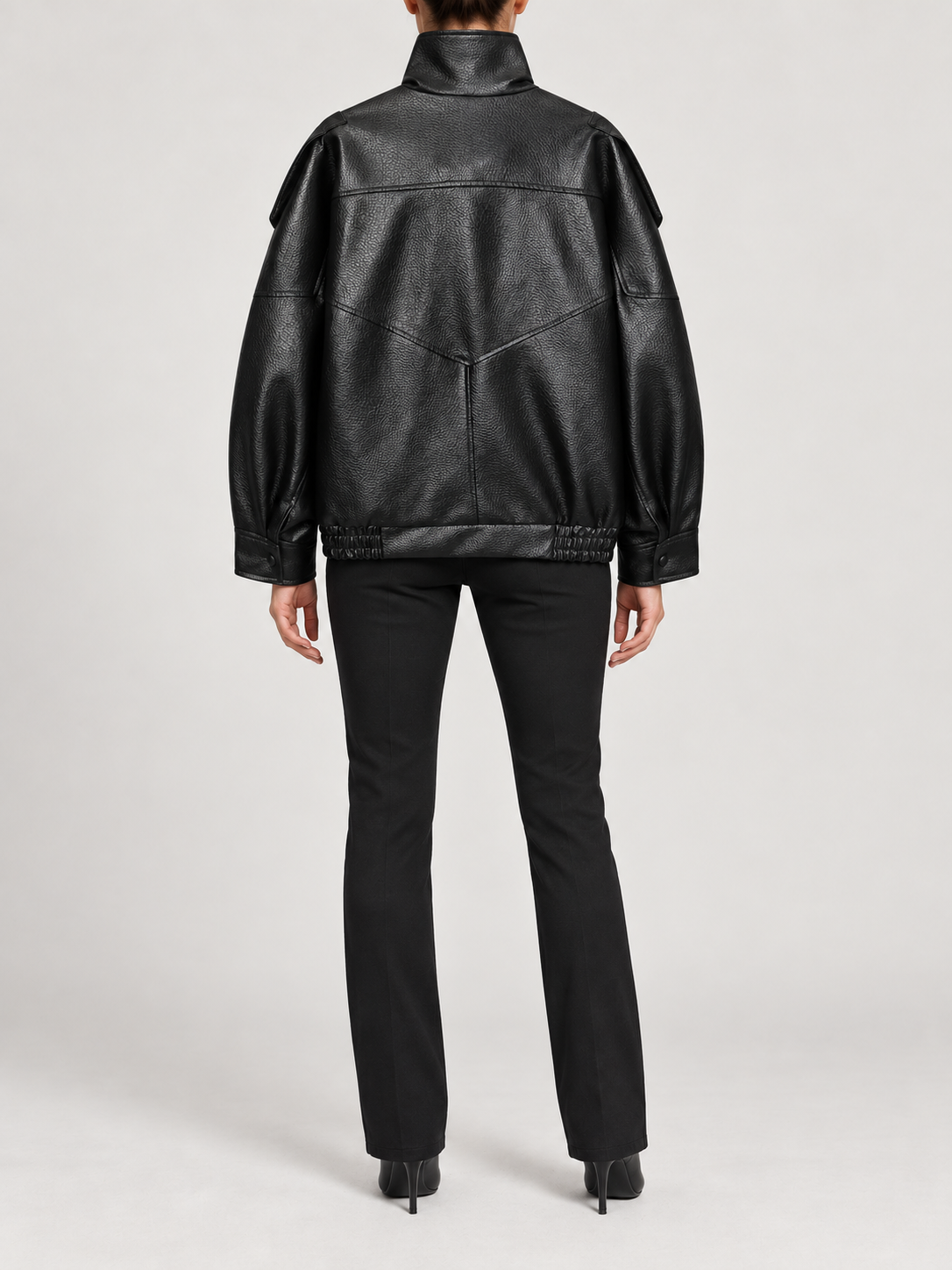 black oversized leather-look bomber with high stand collar and elastic hem, back view on a model