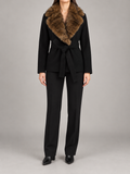 black hip-length wrap coat with brown faux-fur shawl collar and fabric waist tie, front view on a model