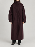 dark plum oversized ankle-length high-neck trench, concealed placket and very wide dropped shoulder sleeves, front view on a model