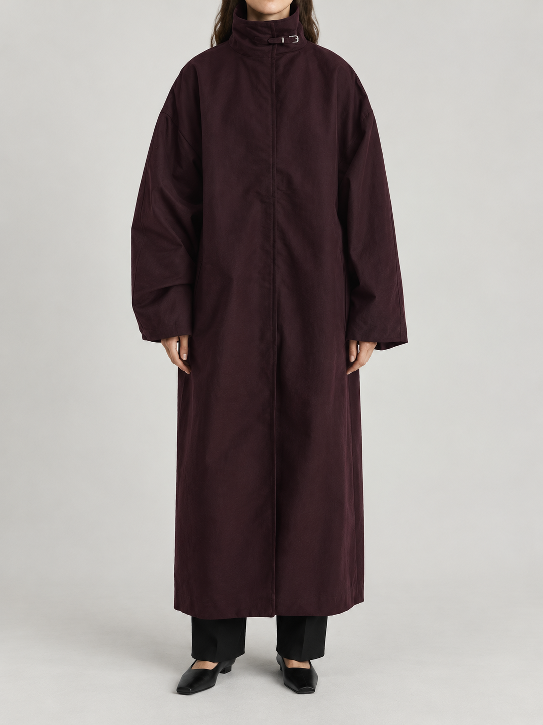 dark plum oversized ankle-length high-neck trench, concealed placket and very wide dropped shoulder sleeves, front view on a model